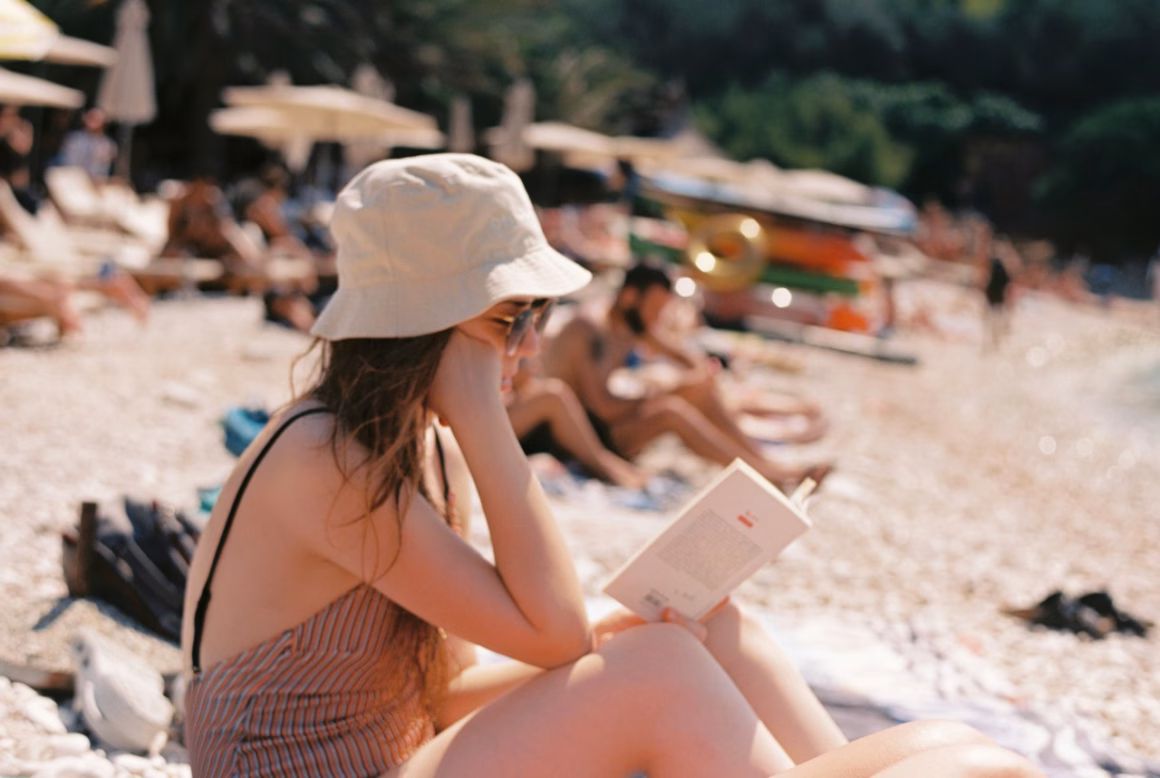 Frau liest am Strand, Bücher für den Sommer 2025