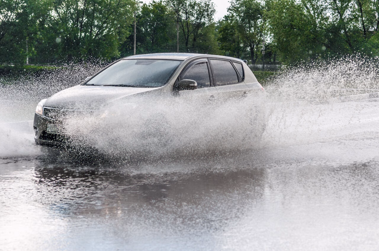 Auto fährt durch Pfütze